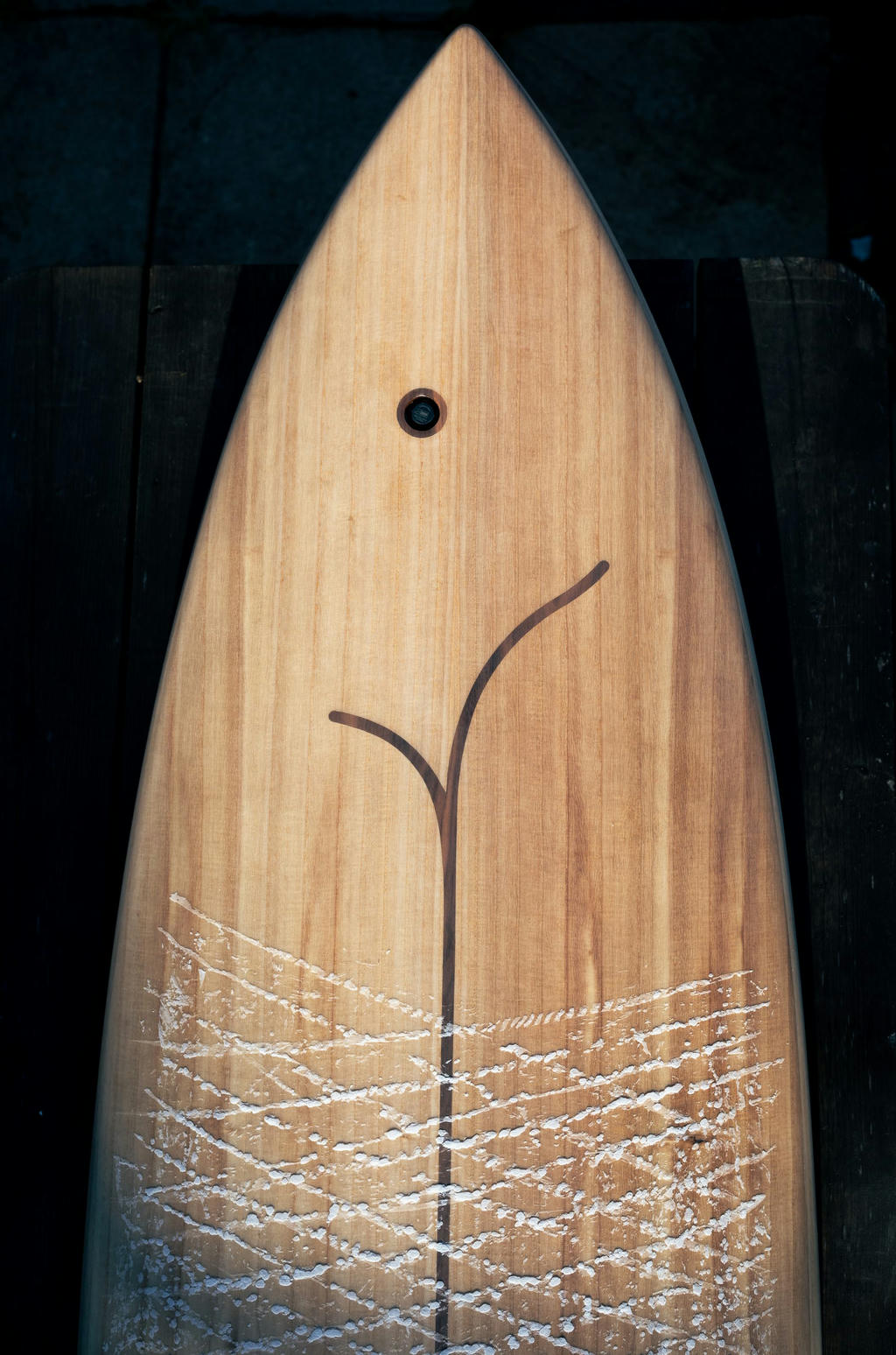 A Bosiny Flagship wooden surfboard freshly waxed
